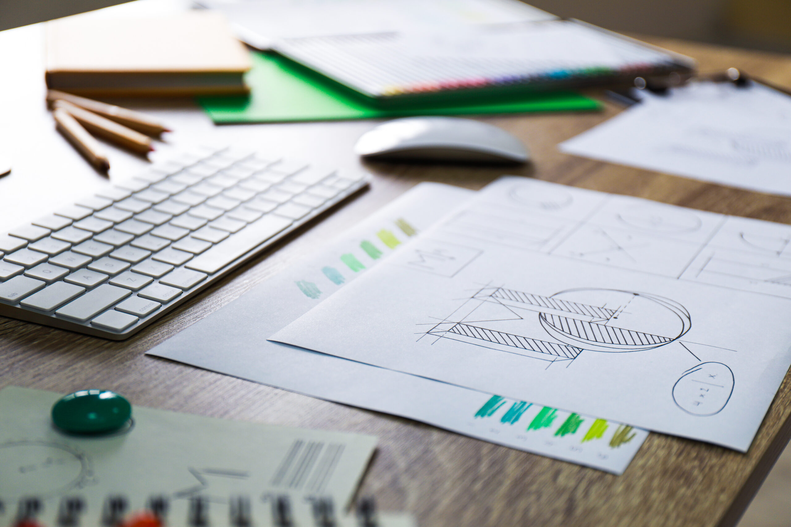 Sheets of paper with sketches on wooden table. Designer’s workplace